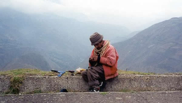 A man rests beside a mountain road in Ecuador.